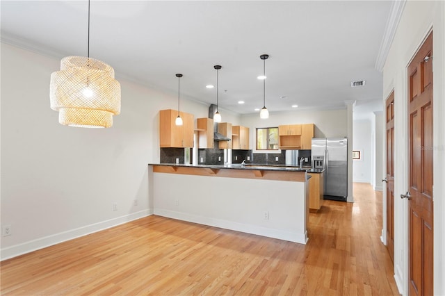 512 S Glen Ave, Tampa, FL 33609 - kitchen featuring stainless steel refrigerator with ice dispenser, a peninsula, tasteful backsplash, ornamental molding, and light wood-type flooring