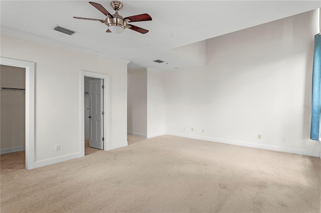 512 S Glen Ave, Tampa, FL 33609 - unfurnished bedroom featuring a walk in closet, crown molding, light colored carpet, and baseboards