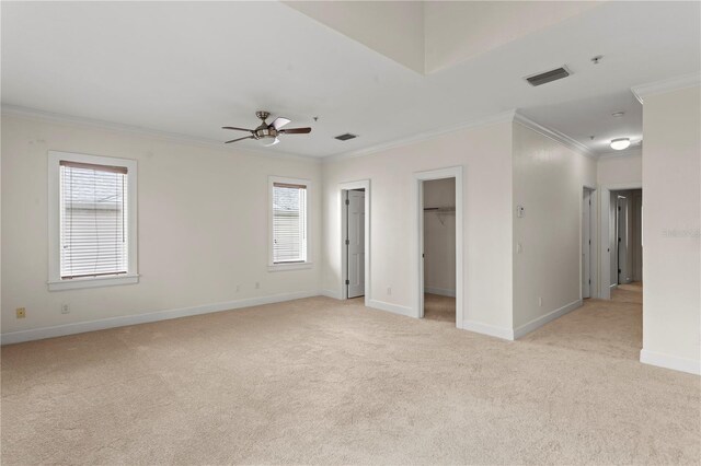512 S Glen Ave, Tampa, FL 33609 - unfurnished bedroom featuring light colored carpet, crown molding, multiple windows, baseboards, and a walk in closet