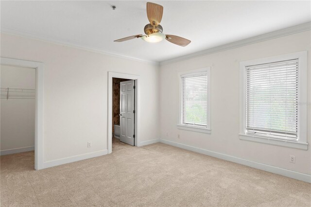 512 S Glen Ave, Tampa, FL 33609 - unfurnished bedroom with light carpet, a spacious closet, ornamental molding, baseboards, and a closet