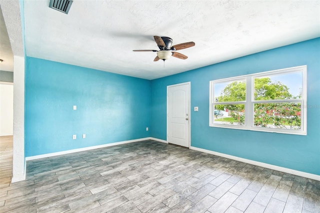 8528 Iris Ave, Seminole, FL 33777 - unfurnished room featuring a ceiling fan, wood finished floors, and baseboards