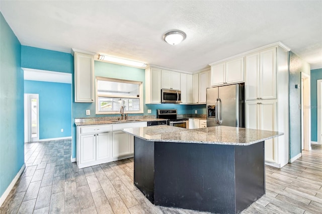 8528 Iris Ave, Seminole, FL 33777 - kitchen featuring appliances with stainless steel finishes, a sink, wood finish floors, and baseboards