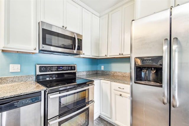 8528 Iris Ave, Seminole, FL 33777 - kitchen with appliances with stainless steel finishes, white cabinets, and light stone countertops