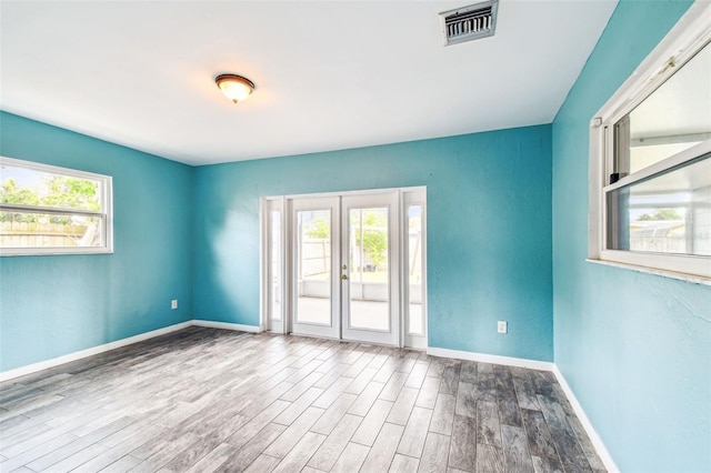 8528 Iris Ave, Seminole, FL 33777 - unfurnished room with plenty of natural light, wood finished floors, and baseboards