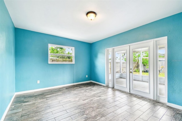 8528 Iris Ave, Seminole, FL 33777 - spare room featuring healthy amount of natural light, wood finished floors, baseboards, and french doors