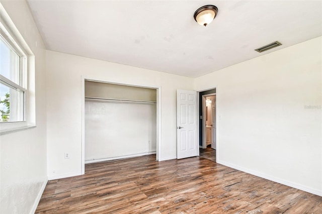 8528 Iris Ave, Seminole, FL 33777 - unfurnished bedroom with wood finished floors, a closet, and baseboards