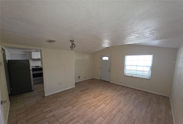4607 N 35th St, Tampa, FL 33610 - entrance foyer with a textured ceiling, light wood-style flooring, vaulted ceiling, and baseboards
