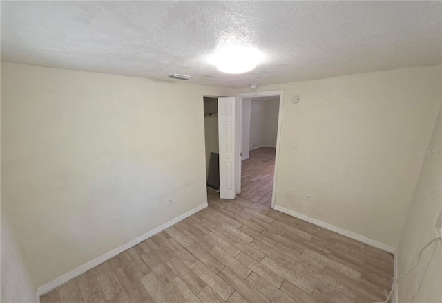 4607 N 35th St, Tampa, FL 33610 - empty room featuring baseboards, light wood finished floors, and a textured ceiling