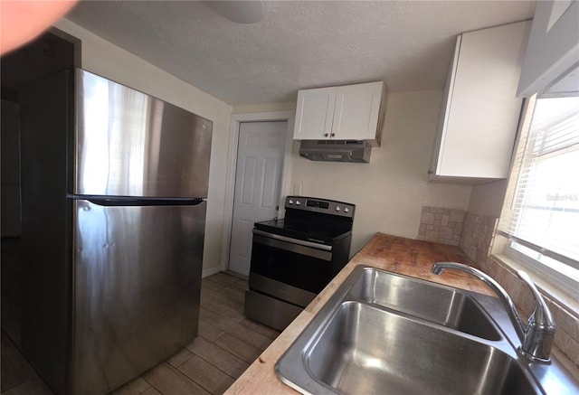 4607 N 35th St, Tampa, FL 33610 - kitchen with stainless steel appliances, a sink, under cabinet range hood, white cabinets, and light countertops