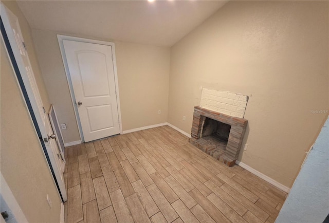 4607 N 35th St, Tampa, FL 33610 - unfurnished living room featuring light wood finished floors, a fireplace, baseboards, and lofted ceiling