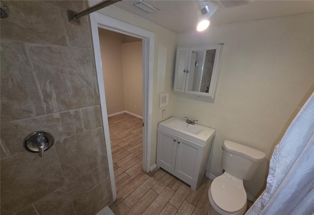 4607 N 35th St, Tampa, FL 33610 - full bathroom featuring wood finish floors, a tile shower, toilet, vanity, and baseboards