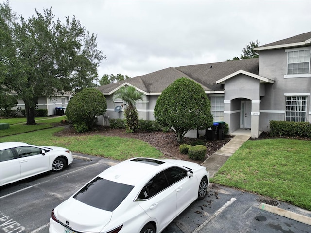 13140 Summerton Dr, Orlando, FL 32824 - view of front of house featuring uncovered parking, a front yard, stucco siding, and roof with shingles