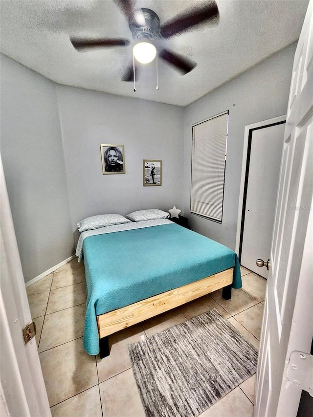 13140 Summerton Dr, Orlando, FL 32824 - bedroom with tile patterned flooring, a textured ceiling, a ceiling fan, and baseboards