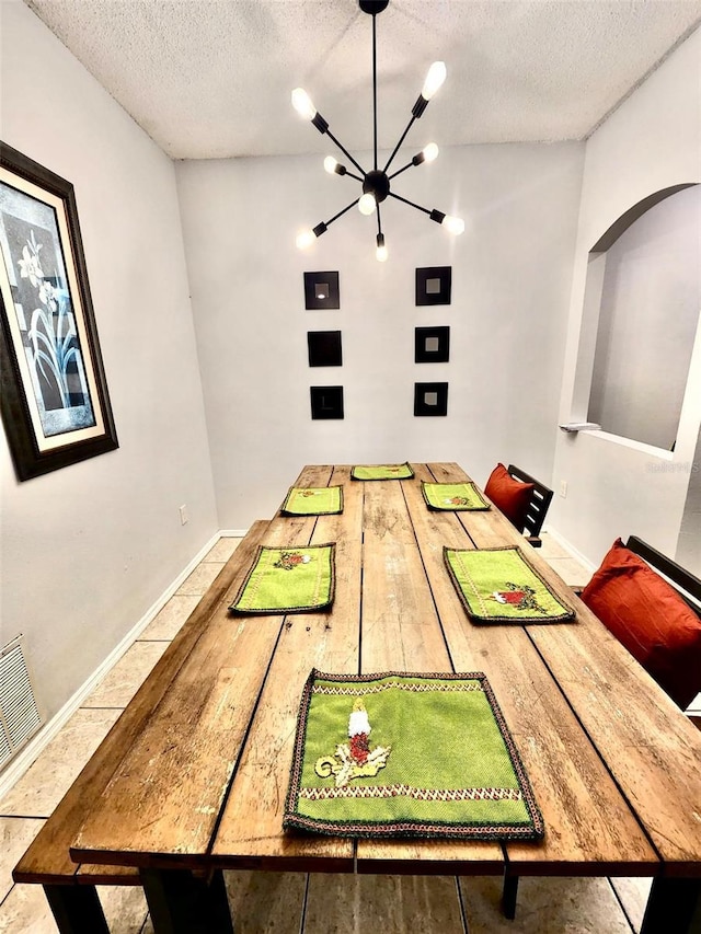 13140 Summerton Dr, Orlando, FL 32824 - dining room featuring a chandelier, a textured ceiling, arched walkways, and baseboards