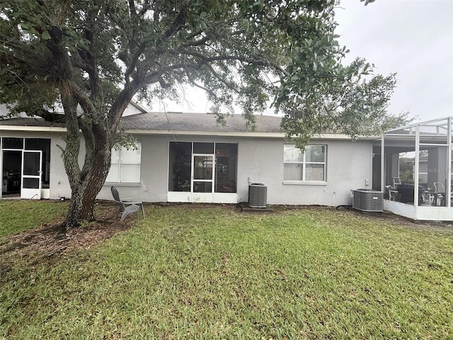 13140 Summerton Dr, Orlando, FL 32824 - rear view of house featuring stucco siding, a sunroom, central AC, and a yard