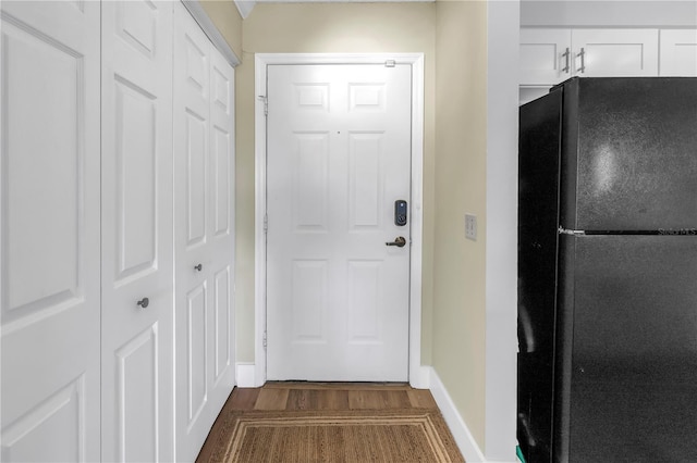 doorway to outside with dark wood-style floors and baseboards