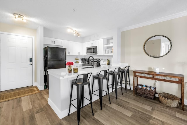 kitchen with stainless steel microwave, a peninsula, open shelves, a breakfast bar area, and stove