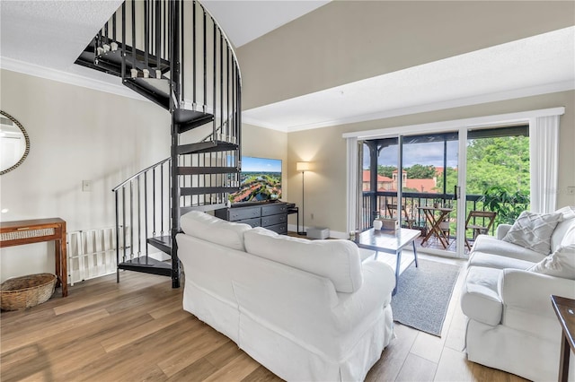 living room featuring crown molding, stairway, and wood finished floors