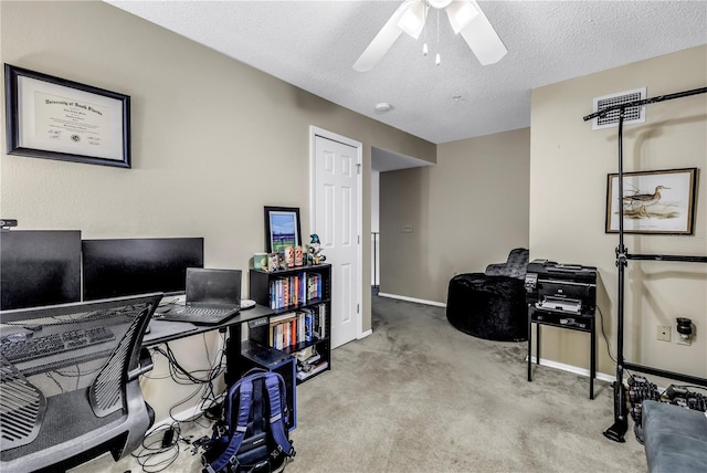carpeted office featuring a ceiling fan, baseboards, and a textured ceiling