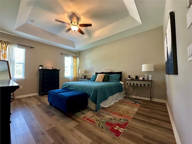 12327 Eagle Swoop Pl, Riverview, FL 33579 - bedroom featuring a tray ceiling, wood finished floors, and baseboards