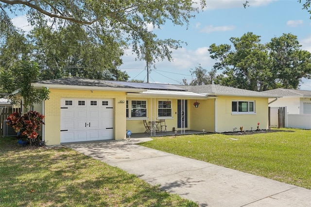 1450 Seabreeze St, Clearwater, FL 33756 - ranch-style home featuring a garage, solar panels, driveway, and stucco siding