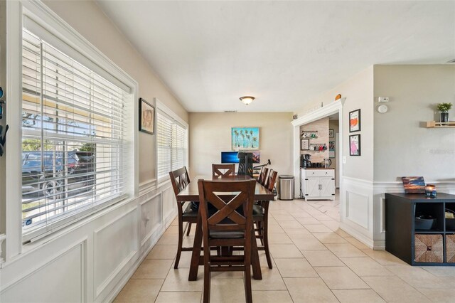 1450 Seabreeze St, Clearwater, FL 33756 - dining room with a decorative wall, light tile patterned flooring, and a wainscoted wall