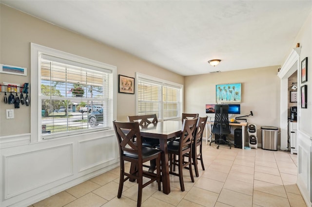 1450 Seabreeze St, Clearwater, FL 33756 - dining area with light tile patterned floors, an office area, wainscoting, and a decorative wall