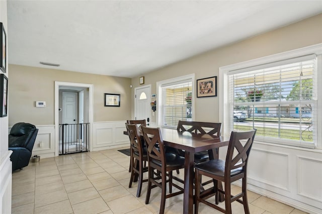 1450 Seabreeze St, Clearwater, FL 33756 - dining area featuring a decorative wall, light tile patterned flooring, and a wainscoted wall