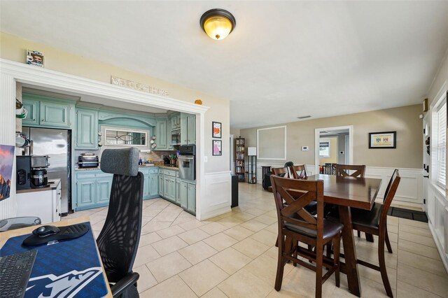 1450 Seabreeze St, Clearwater, FL 33756 - dining room with light tile patterned floors and a wainscoted wall