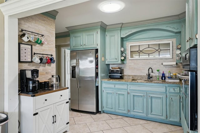 1450 Seabreeze St, Clearwater, FL 33756 - kitchen with stainless steel refrigerator with ice dispenser, decorative backsplash, light tile patterned floors, a sink, and dark stone counters
