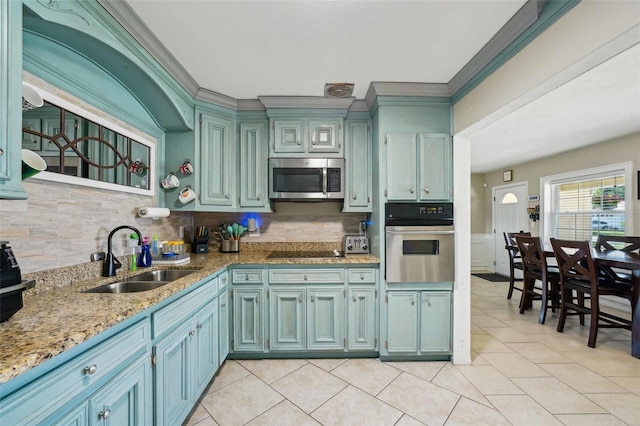 1450 Seabreeze St, Clearwater, FL 33756 - kitchen featuring appliances with stainless steel finishes, a sink, backsplash, light tile patterned flooring, and ornamental molding