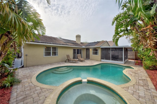 1955 Cobblestone Way, Clearwater, FL 33760 - view of pool with a sunroom, a pool with connected hot tub, and a patio