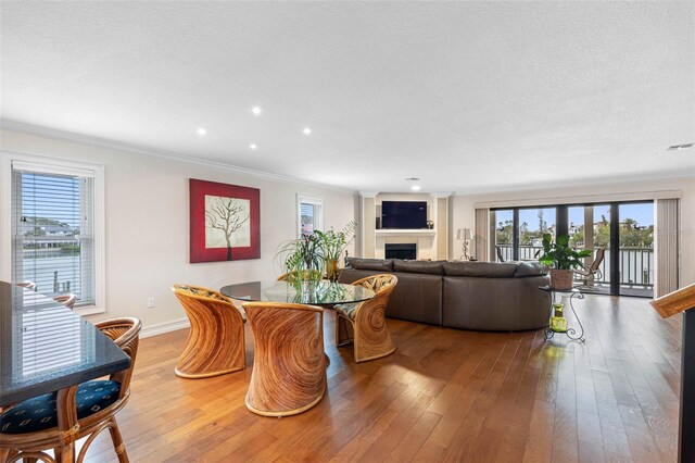 12360 Capri Cir N Unit 106, Treasure Island, FL 33706 - dining area with healthy amount of natural light, light wood finished floors, a fireplace, crown molding, and recessed lighting