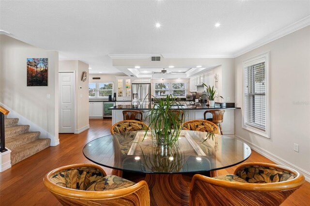 12360 Capri Cir N Unit 106, Treasure Island, FL 33706 - dining area featuring wine cooler, wood finished floors, ceiling fan, crown molding, and stairway