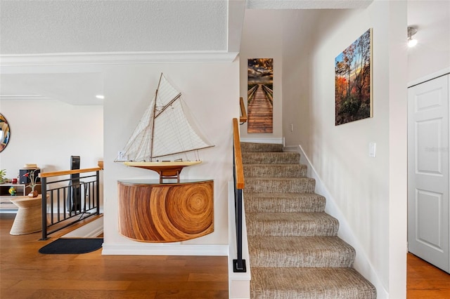 12360 Capri Cir N Unit 106, Treasure Island, FL 33706 - stairway featuring wood finished floors, baseboards, and a textured ceiling