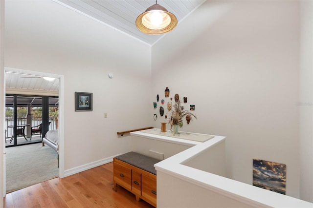 12360 Capri Cir N Unit 106, Treasure Island, FL 33706 - corridor featuring light wood-type flooring, an upstairs landing, wood ceiling, baseboards, and high vaulted ceiling