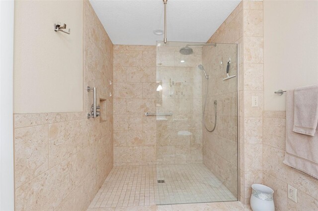 12360 Capri Cir N Unit 106, Treasure Island, FL 33706 - full bath with tile walls, a walk in shower, and wainscoting