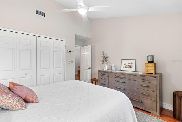 12360 Capri Cir N Unit 106, Treasure Island, FL 33706 - bedroom with a closet, wood finished floors, high vaulted ceiling, baseboards, and a ceiling fan