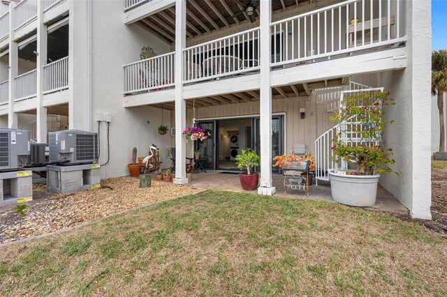 12360 Capri Cir N Unit 106, Treasure Island, FL 33706 - back of house with central AC unit, stucco siding, a lawn, and a patio area