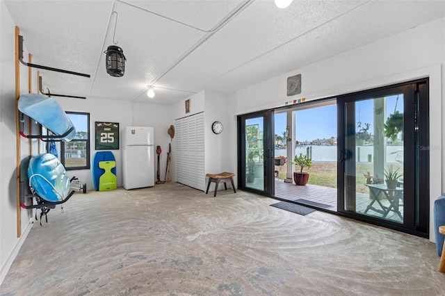 12360 Capri Cir N Unit 106, Treasure Island, FL 33706 - garage with freestanding refrigerator, a water view, and baseboards