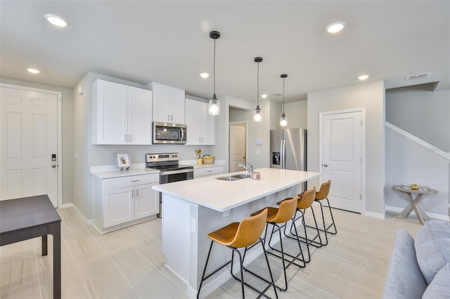 7709 Imagination Pl, Wesley Chapel, FL 33545 - kitchen featuring appliances with stainless steel finishes, a breakfast bar area, a sink, white cabinets, and baseboards