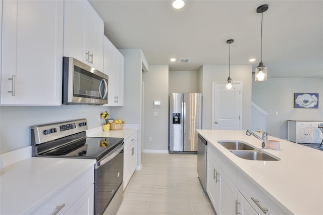 7709 Imagination Pl, Wesley Chapel, FL 33545 - kitchen with appliances with stainless steel finishes, a sink, light countertops, hanging light fixtures, and recessed lighting