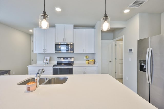 7709 Imagination Pl, Wesley Chapel, FL 33545 - kitchen with appliances with stainless steel finishes, light countertops, a sink, white cabinets, and recessed lighting