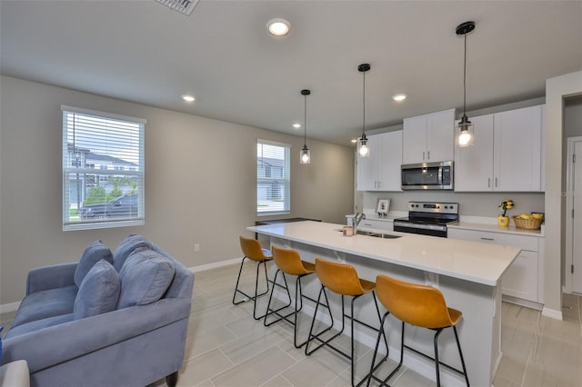 7709 Imagination Pl, Wesley Chapel, FL 33545 - kitchen with appliances with stainless steel finishes, open floor plan, a sink, a breakfast bar, and light countertops