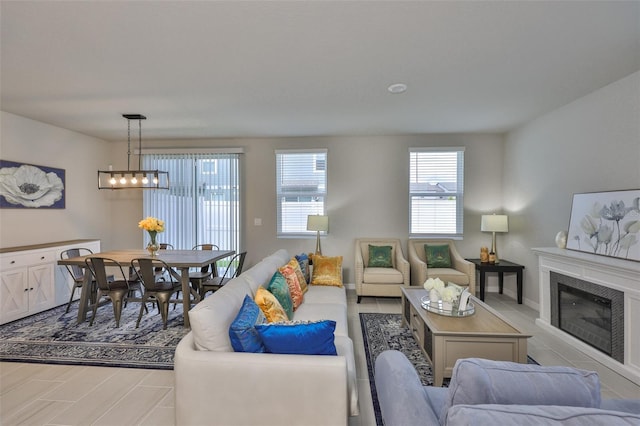 7709 Imagination Pl, Wesley Chapel, FL 33545 - living room featuring plenty of natural light, a chandelier, a fireplace, and wood finished floors