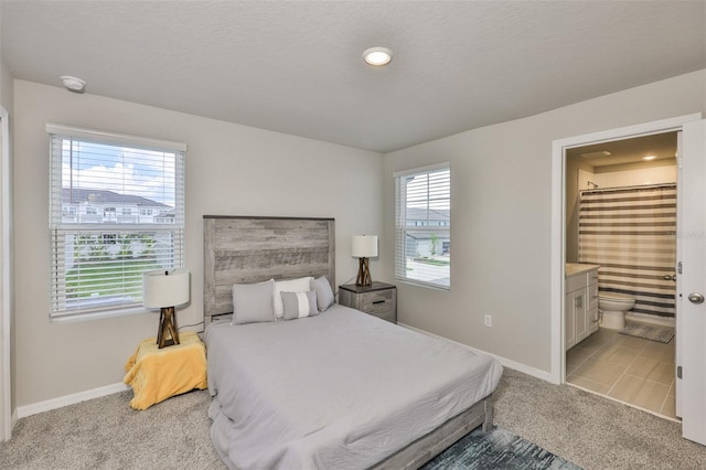 7709 Imagination Pl, Wesley Chapel, FL 33545 - bedroom with light colored carpet, baseboards, and ensuite bath