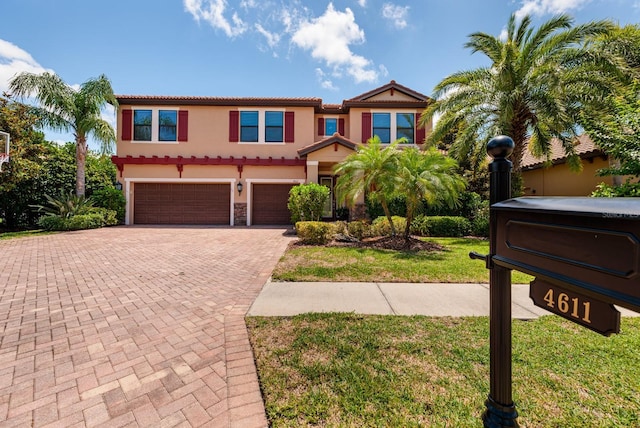 4611 Grand Preserve Pl, Palm Harbor, FL 34684 - mediterranean / spanish-style home featuring a tiled roof, a garage, decorative driveway, stucco siding, and a front yard