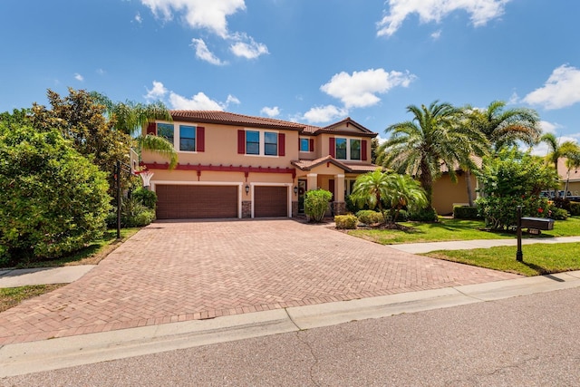 4611 Grand Preserve Pl, Palm Harbor, FL 34684 - mediterranean / spanish-style house with decorative driveway, a tile roof, a garage, stucco siding, and a front yard