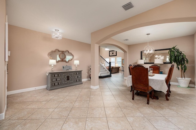 4611 Grand Preserve Pl, Palm Harbor, FL 34684 - dining room featuring stairs, arched walkways, a chandelier, and light tile patterned floors