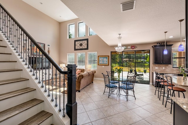 4611 Grand Preserve Pl, Palm Harbor, FL 34684 - dining space with a chandelier, stairs, light tile patterned floors, baseboards, and a high ceiling